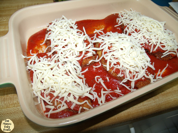 Chicken and sauce in a dish with cheese on top