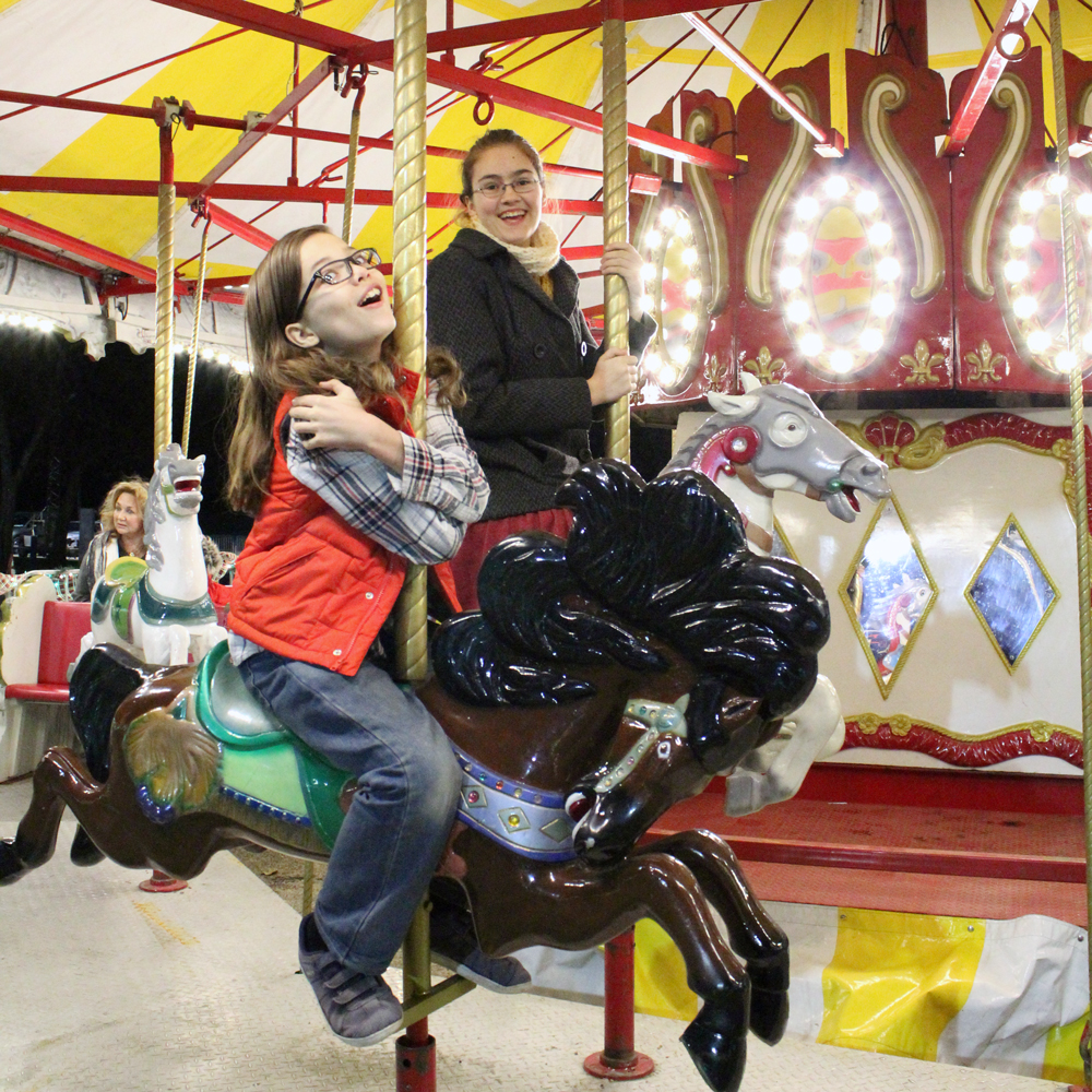 2 kids riding a carousel and making dramatic faces