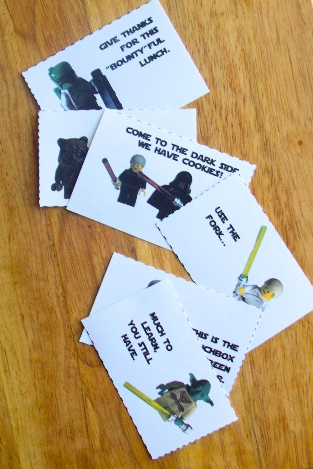 Paper LEGO Star Wars lunchbox notes with punny quotes from characters, including "much to learn you still have."