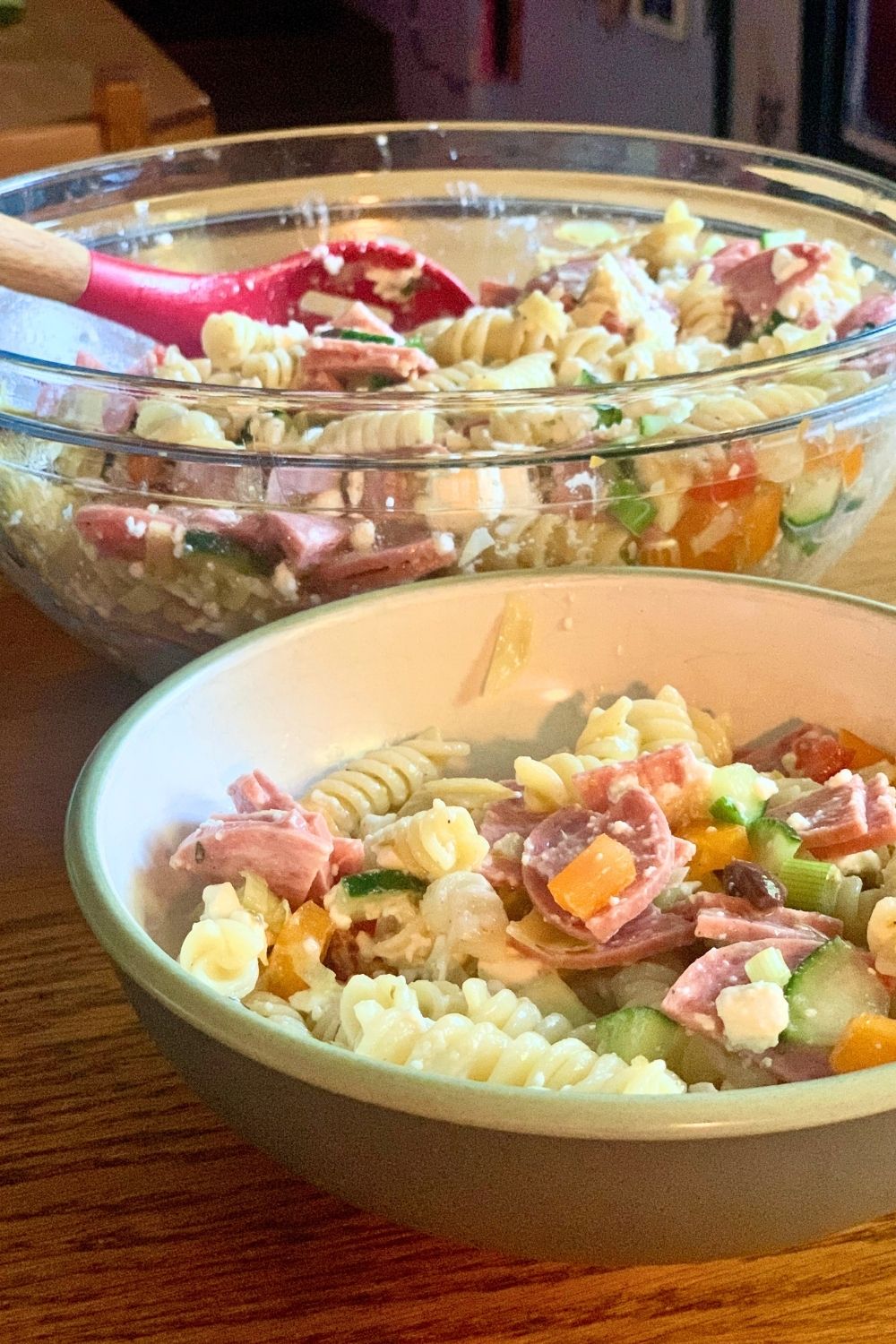 A bowl of pasta salad beside the main serving dish.
