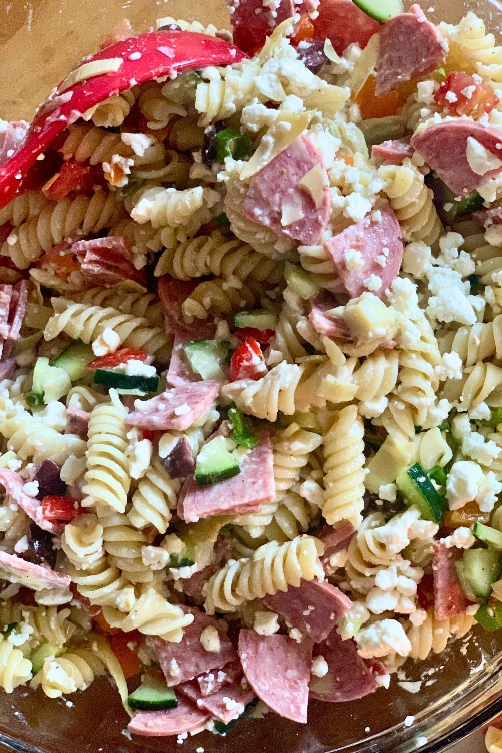 Closeup of Greek pasta salad showing the texture of feta, cucumbers, and other ingredients.