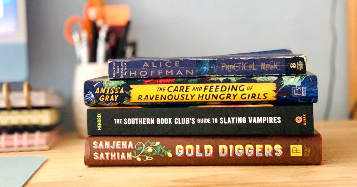 Stack of books for moms including 14 summer reading books for moms including Practical Magic, The Care and Feeding of Ravenously Hungry Girls, The Southern Book Club's Guide to Slaying Vampires, and Gold Diggers.
