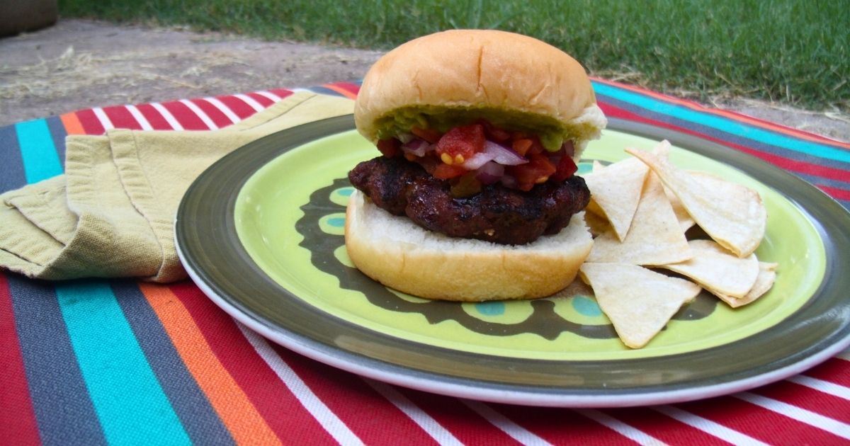 The Texas burger is a tex-mex seasoned patty with guacamole and salsa on a bun.