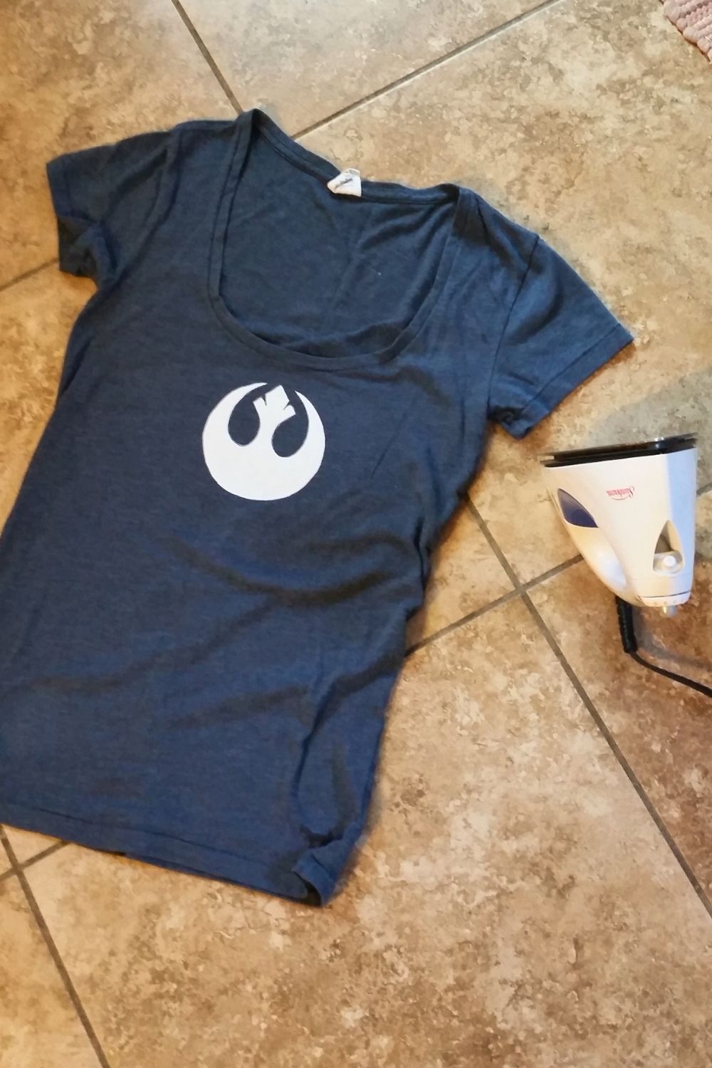 An iron beside a navy tee shirt with a paper rebel stencil in the center.
