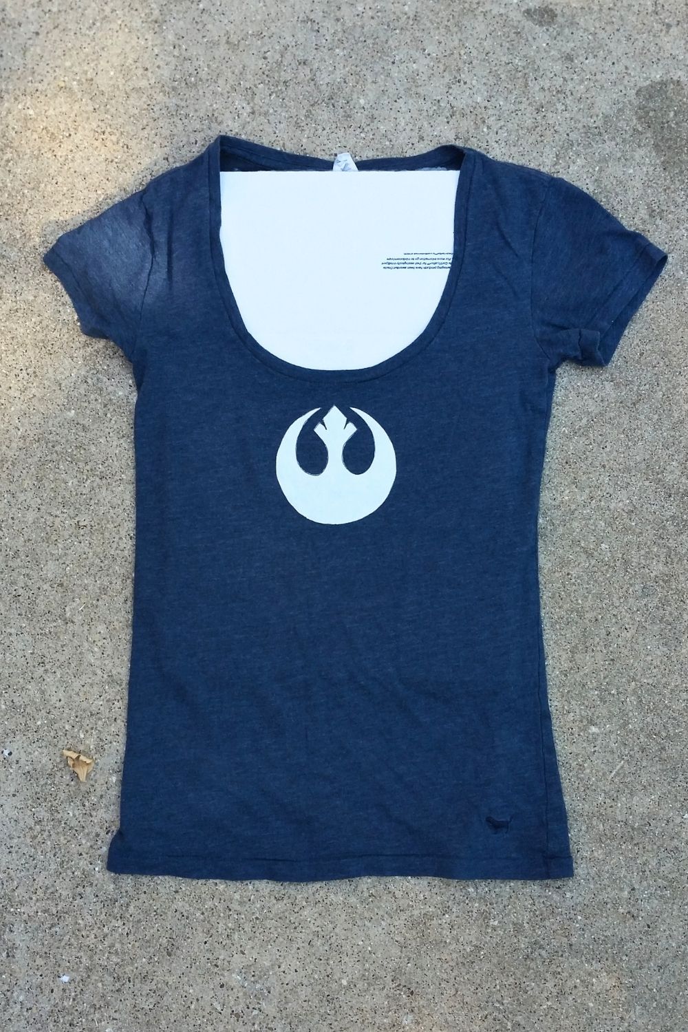 A navy shirt with a paper stencil on the front and cardboard inside.