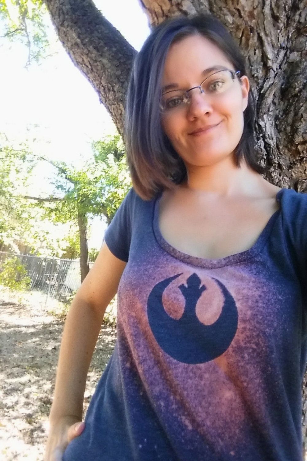 A person wearing a pink and blue DIY bleach shirt with the Star Wars rebels logo.
