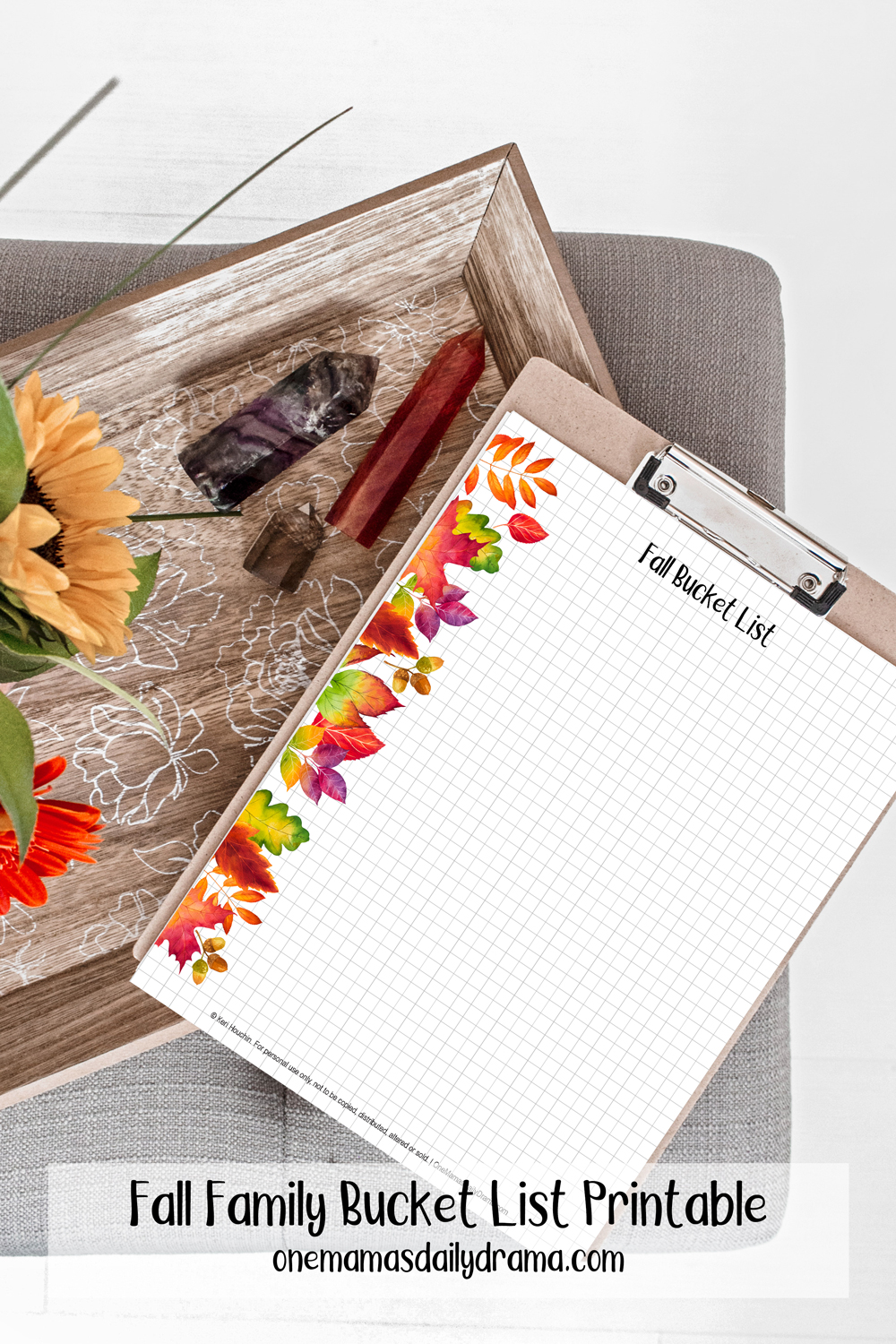 clipboard with a fall bucket list on grid paper with watercolor leaves along the left margin