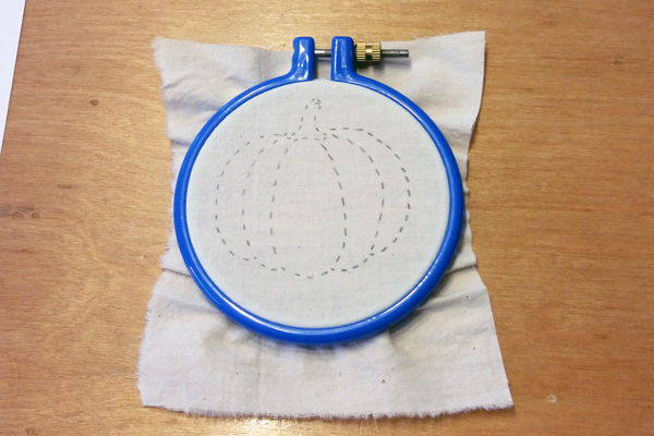 pumpkin pattern drawn on fabric in an embroidery hoop