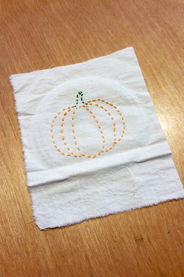 finished orange and green pumpkin stitched on fabric