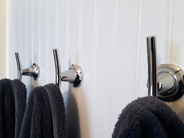 metal wall hooks holding towels in a bathroom