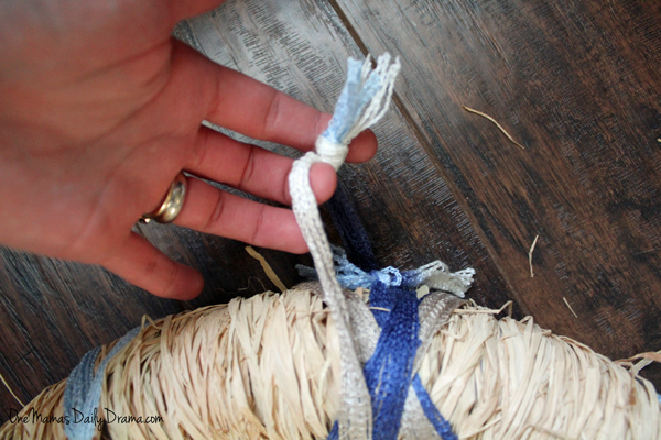 Tying a loop of yarn to hang the wreath.