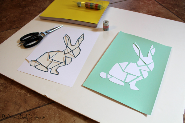 Pieces of bunny template cut out and laid on green paper.