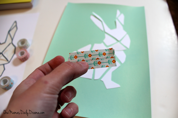 Hand holding strips of green flower washi tape.