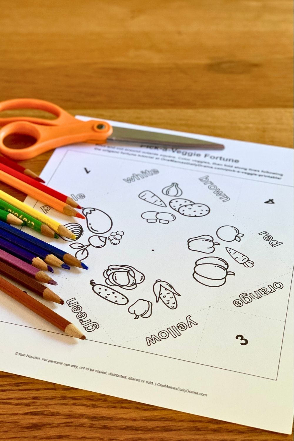 Printed cootie catcher with black-and-white vegetable icons to color with pencils.