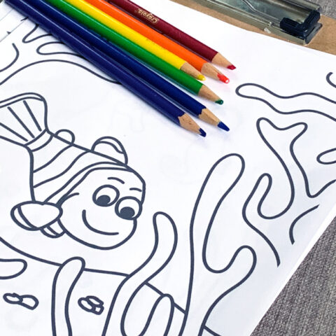 Printable ocean coloring page with a clownfish swimming around coral.