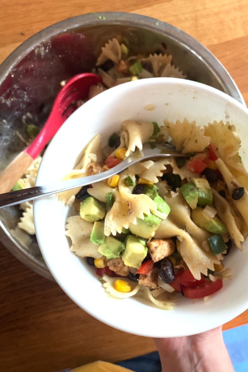 A bowl full of chicken and pasta.