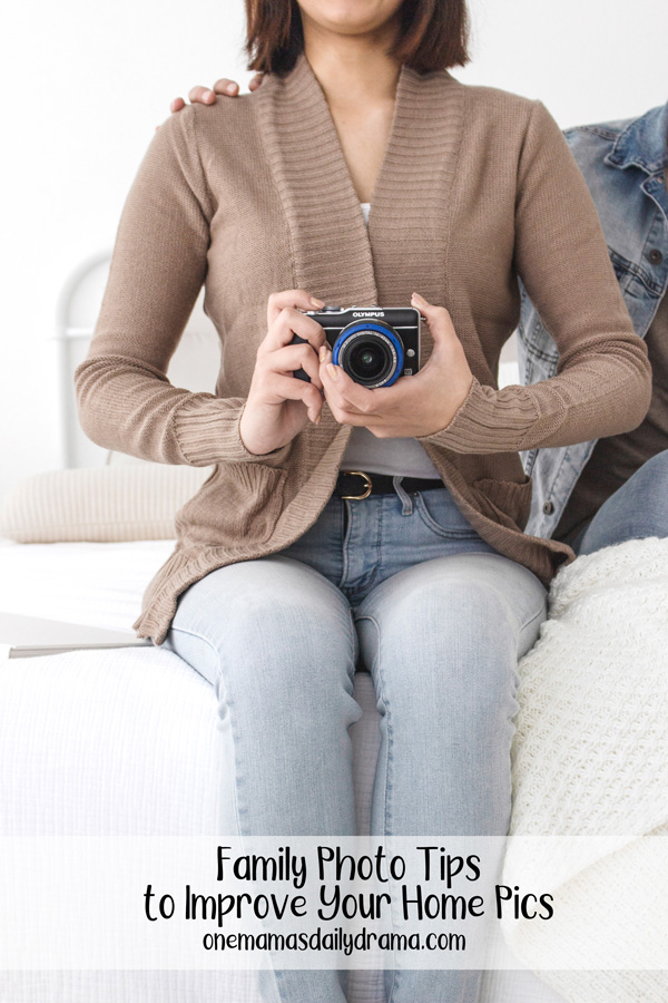 woman in a brown sweater holding a camera at waist height with text overlay "family photo tips to improve your home pics"