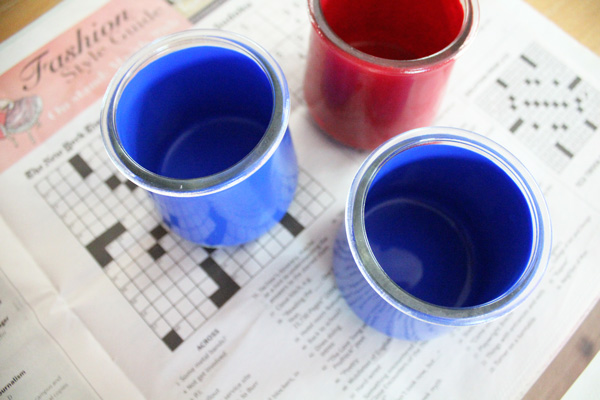 A red painted jar beside 2 blue ones.