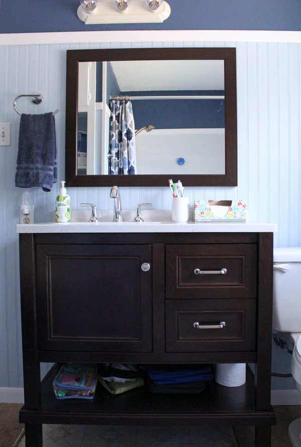 bathroom remodel: sink vanity and mirror with fixtures and blue walls