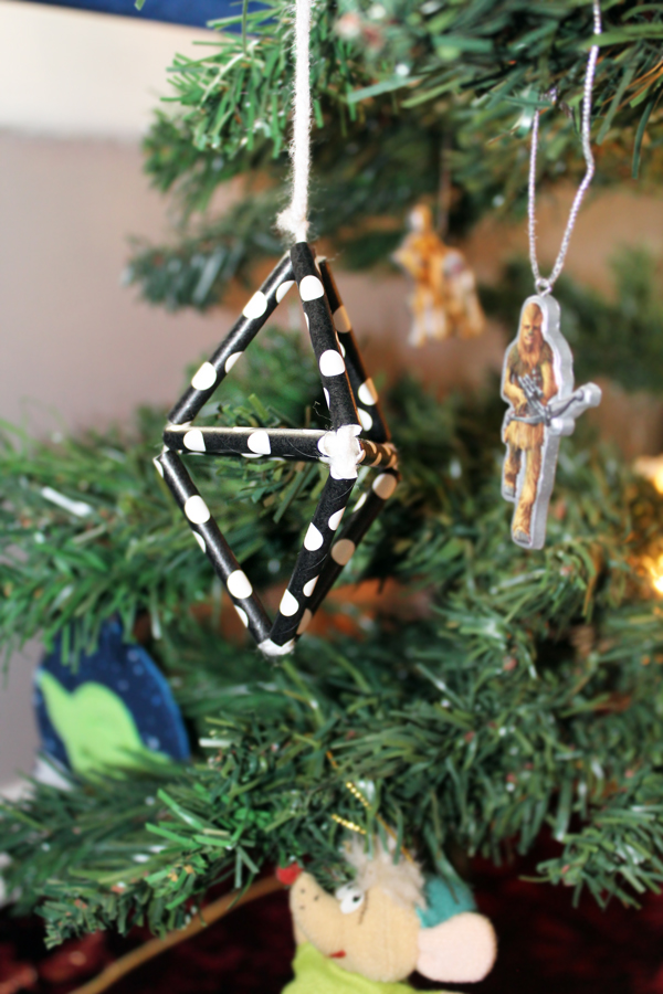3d ornament made from paper straws hanging on a Christmas tree
