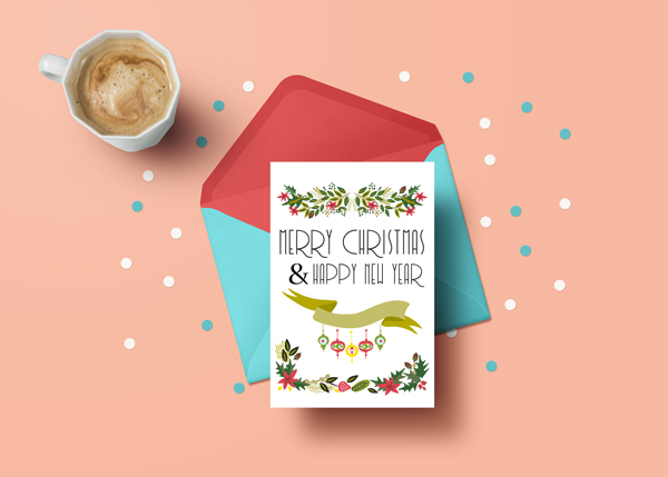 white greeting card on a blue envelope reads "Merry Christmas & Happy New Year" with vintage Christmas greenery