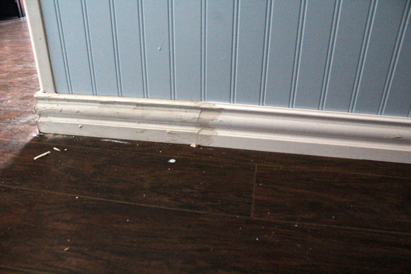 A baseboard that has been damaged is repaired as part of an entryway makeover.