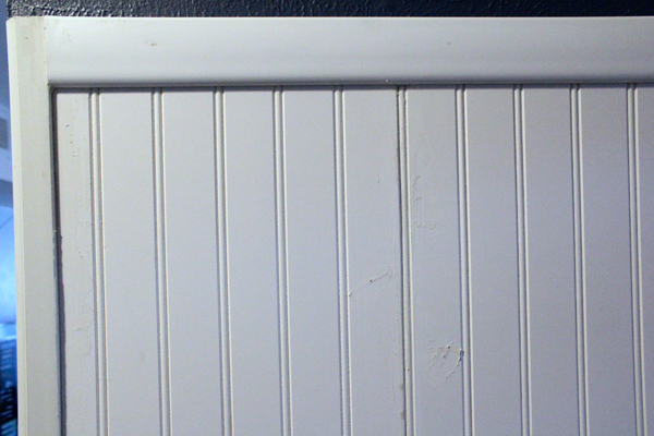 Coseup of paneling with mud covering nail heads.