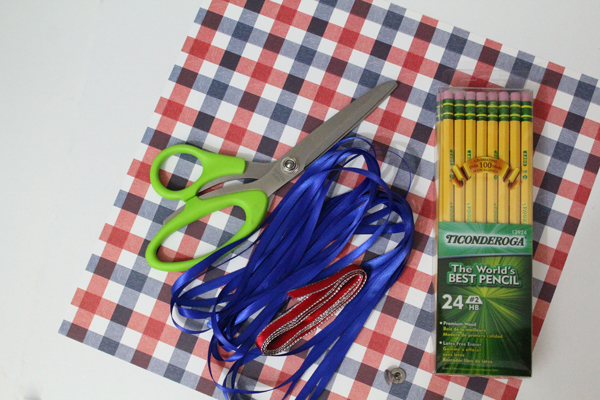 red and blue scrapbook paper, scissors, ribbon, and pencils