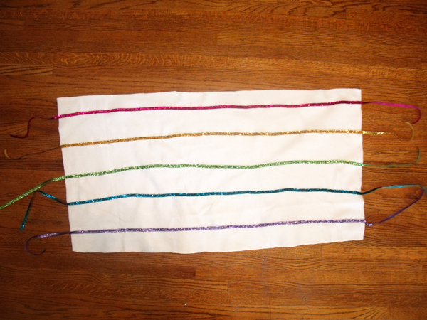 5 colored ribbons lined up on the white fleece pillow fabric
