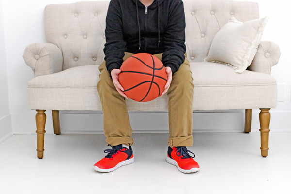 child sitting on a sofa with a basketball