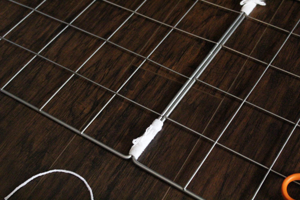 two chrome grid squares tied together with white yarn