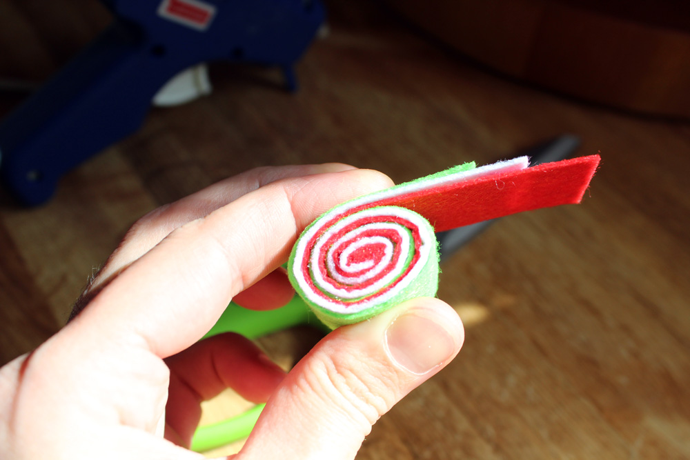 hand rolling felt pieces into a spiral candy circle
