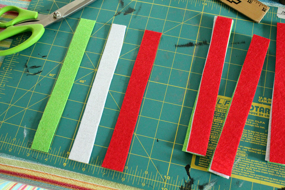green, white, and felt strips on a cutting mat