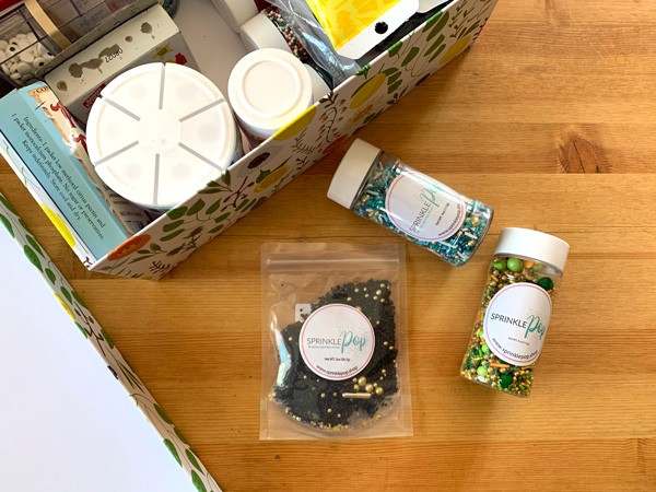 2 jars and 1 bag of sprinkles on a kitchen counter