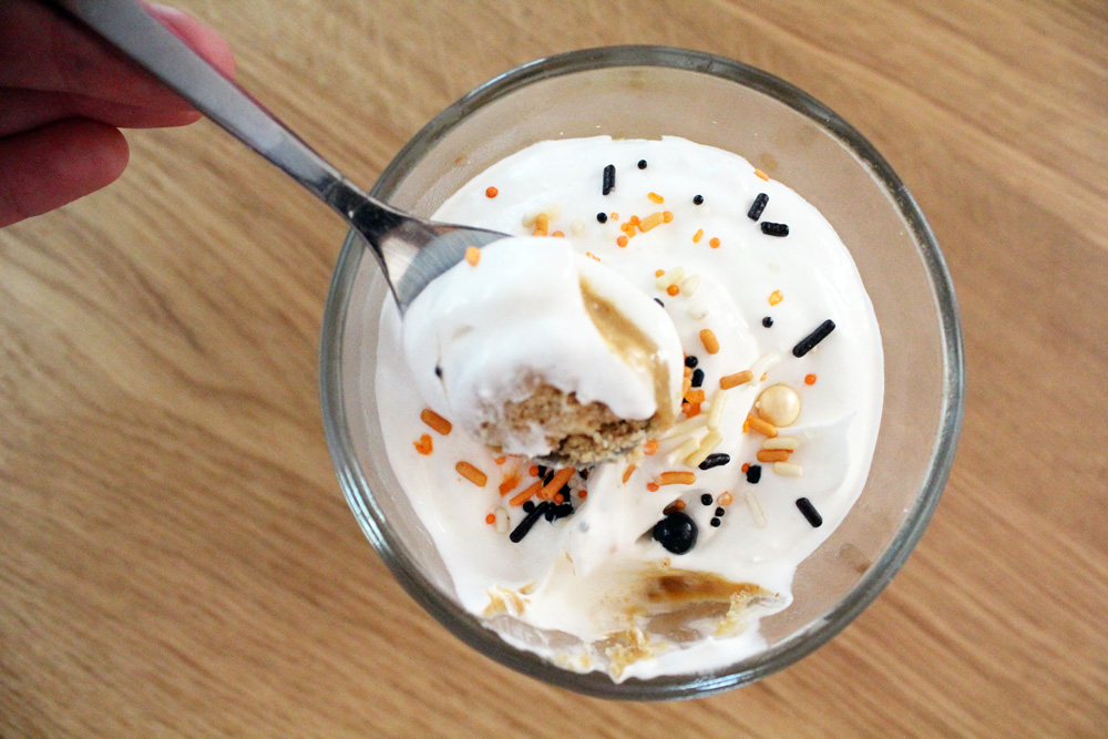 Scooping a spoonful from a cup of pudding.
