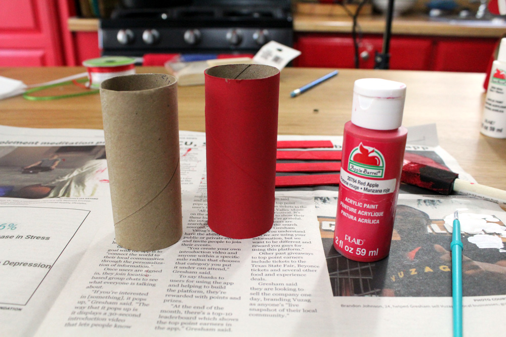 A brown toilet paper tube beside another one painted red.