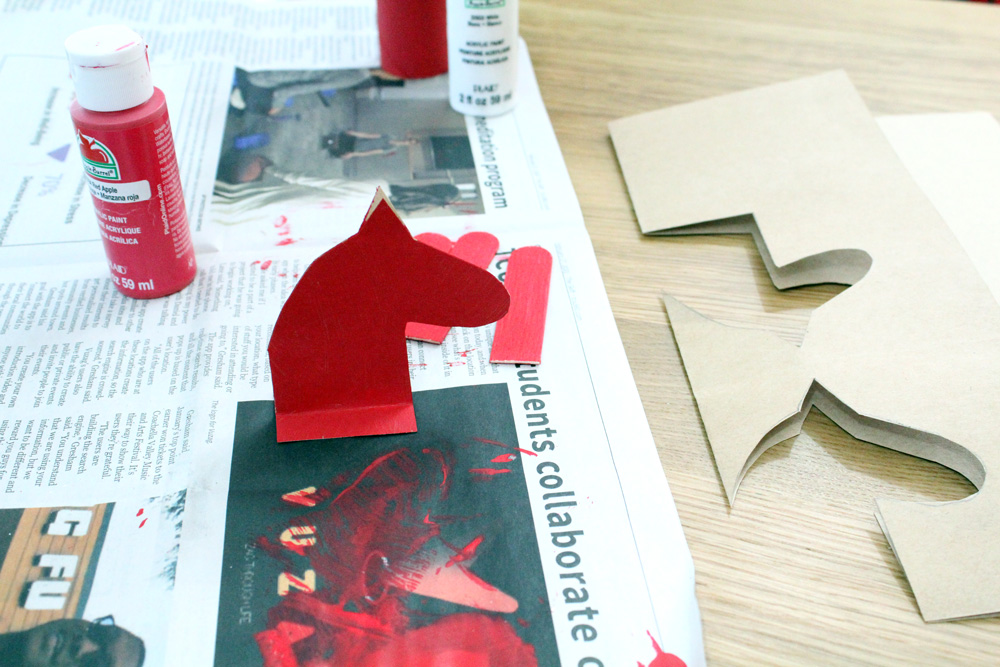 A paper cutout of a horse head painted red.