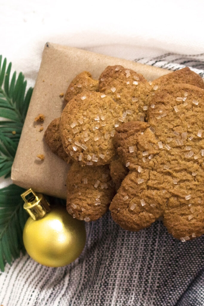 Stack of gingerbread man cookies on a brown paper gift.