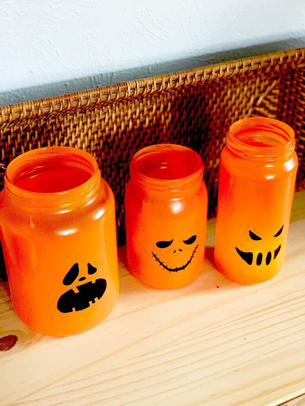Orange pumpkin jars with scary Halloween faces.