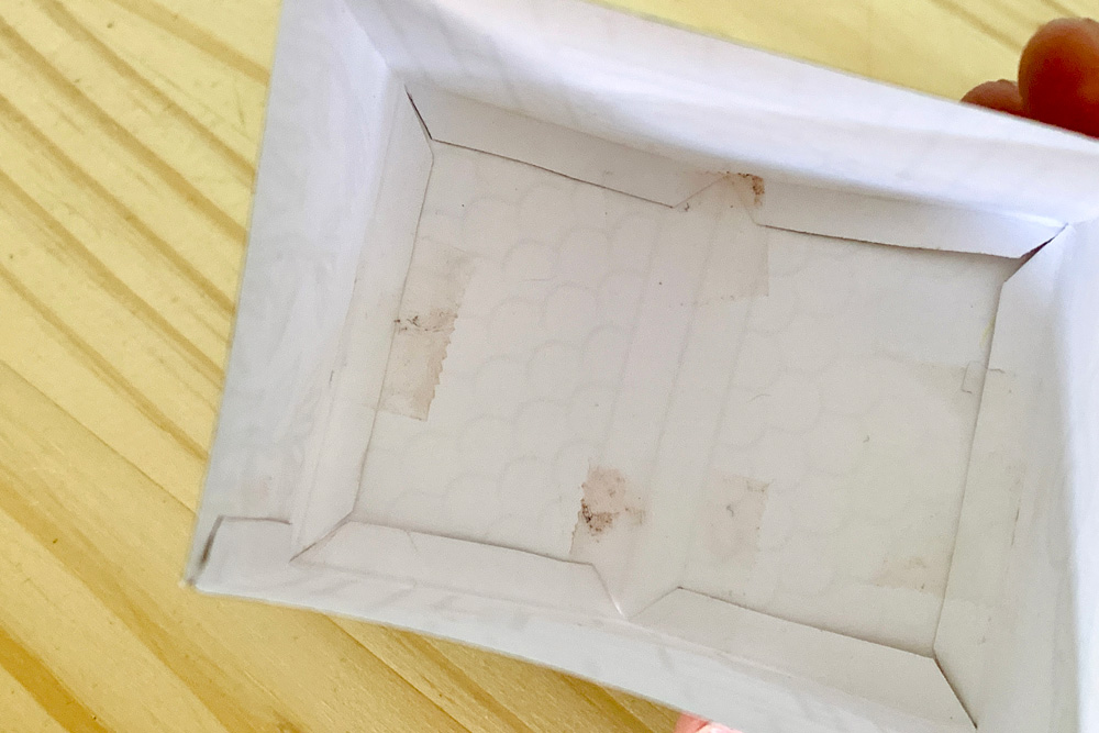 Inside view of a paper house with tabs folded against the roof piece.