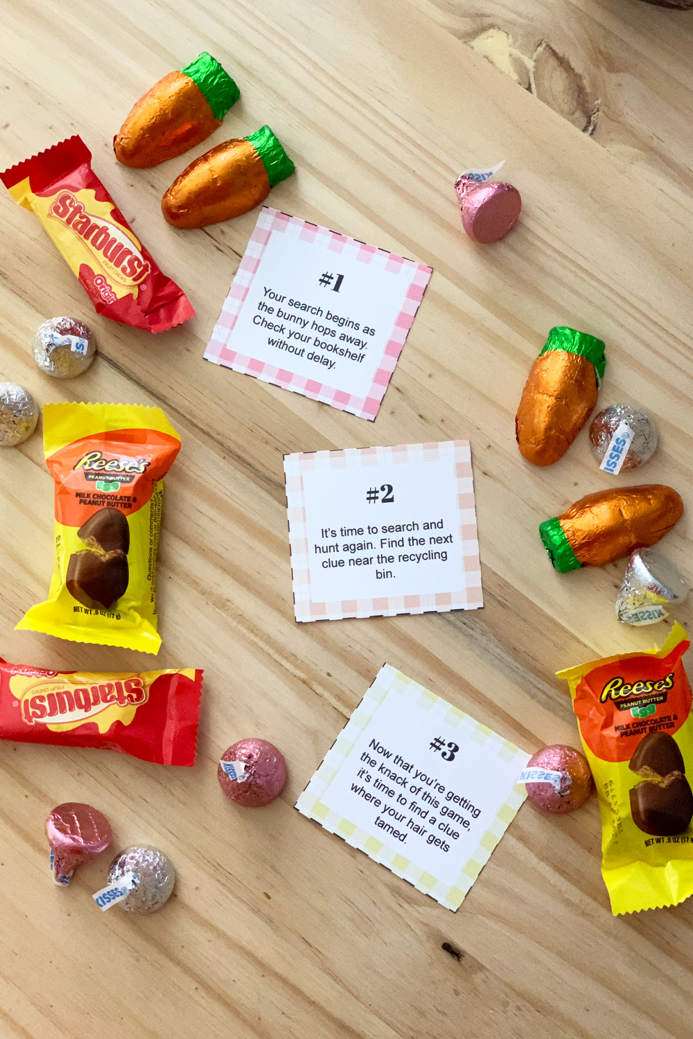 3 Easter scavenger hunt clues on pastel paper surrounded by chocolate candy.
