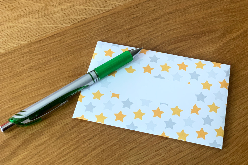 An envelope with gold and gray stars and a blank space in the center.