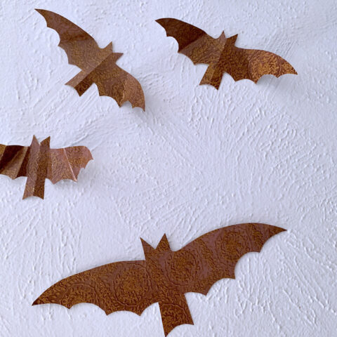 Printable paper bat decor attached to a wall for Halloween.