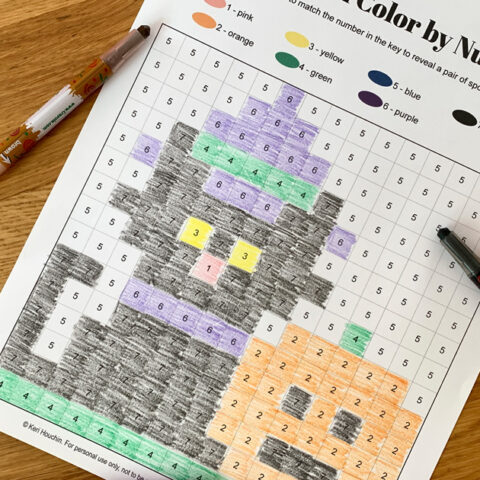 Halloween color by number pixel art showing a black cat wearing a purple witch's hat and smiling jack o'lantern.