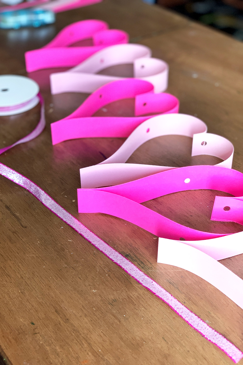 Paper hearts with holes punch along the center.