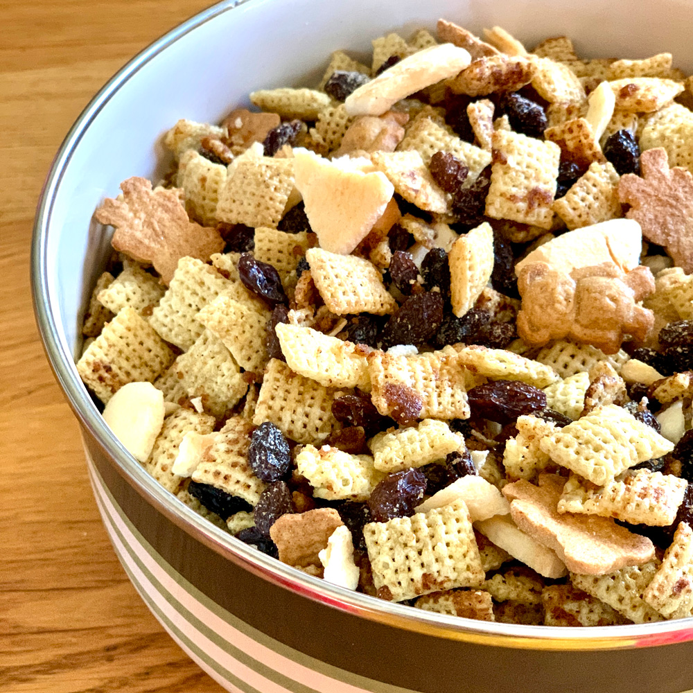 Bowl of apple cinnamon chex mix with raisins and teddy grahams.
