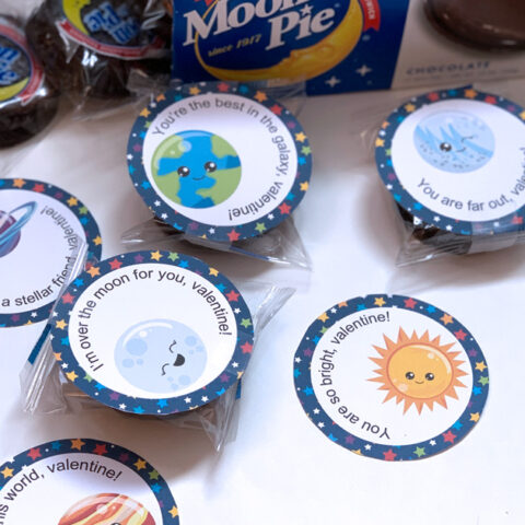 Round space valentines cards with cartoon planets and puns attached to Moon Pies.