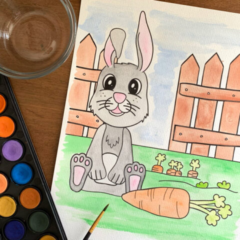 Watercolor painted gray bunny coloring page with orange carrots in a green garden surrounded by a brown fence.