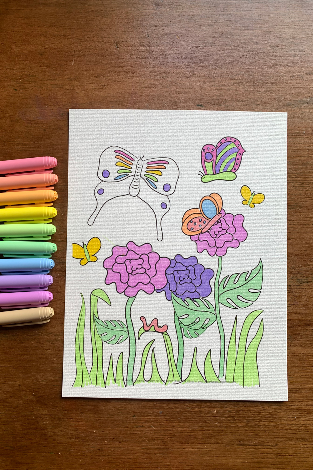 Butterfly coloring page colored with pastel markers in pink, yellow, green, and purple.