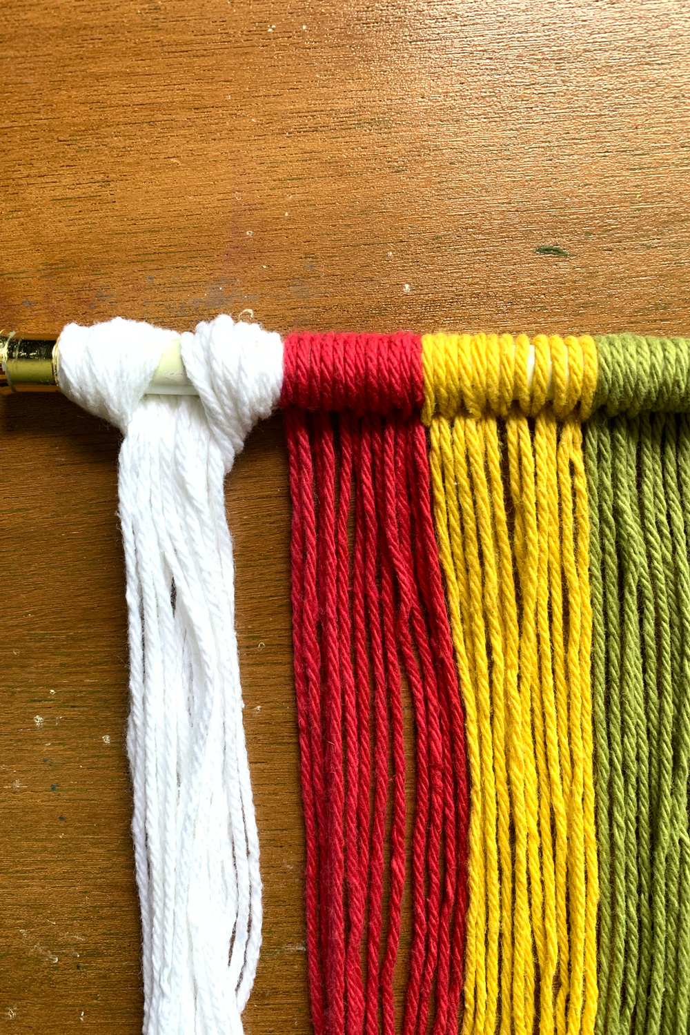 White yarn in a hitch knot beside a red yarn section.